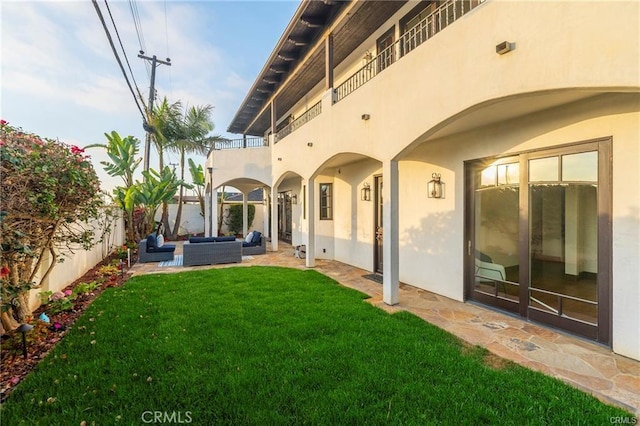 rear view of property with a lawn, an outdoor hangout area, a patio area, and a balcony