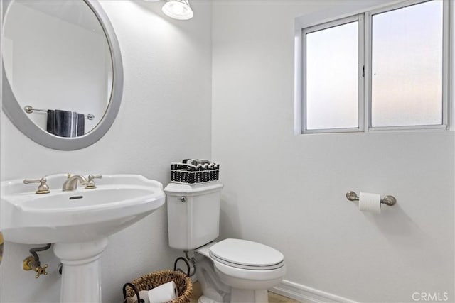 bathroom with sink, a wealth of natural light, and toilet