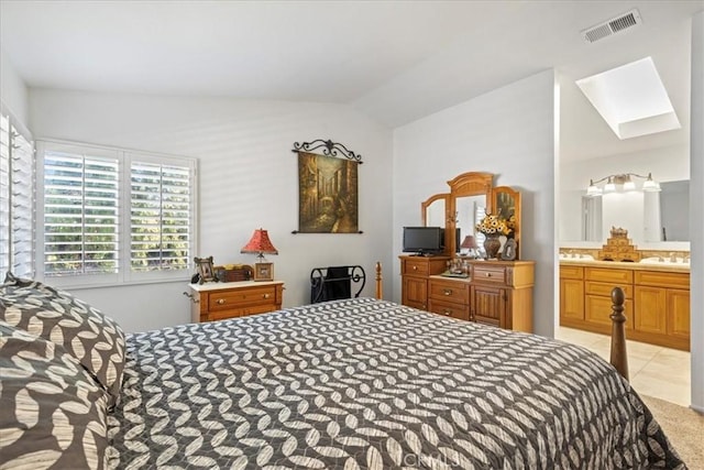 bedroom featuring vaulted ceiling with skylight and ensuite bathroom