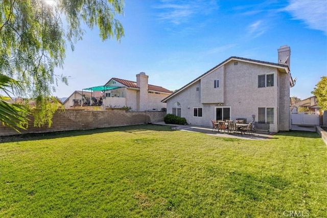 back of property featuring a lawn and a patio