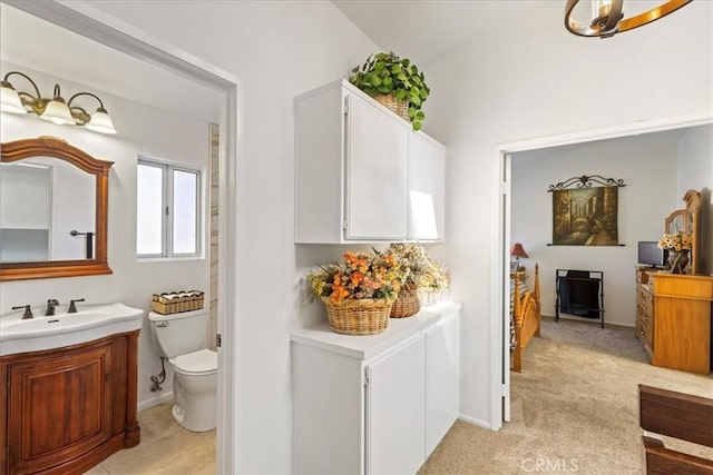 bathroom featuring toilet, vanity, and a chandelier