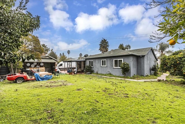 rear view of property featuring a lawn