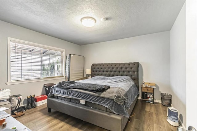 bedroom featuring hardwood / wood-style floors and a textured ceiling