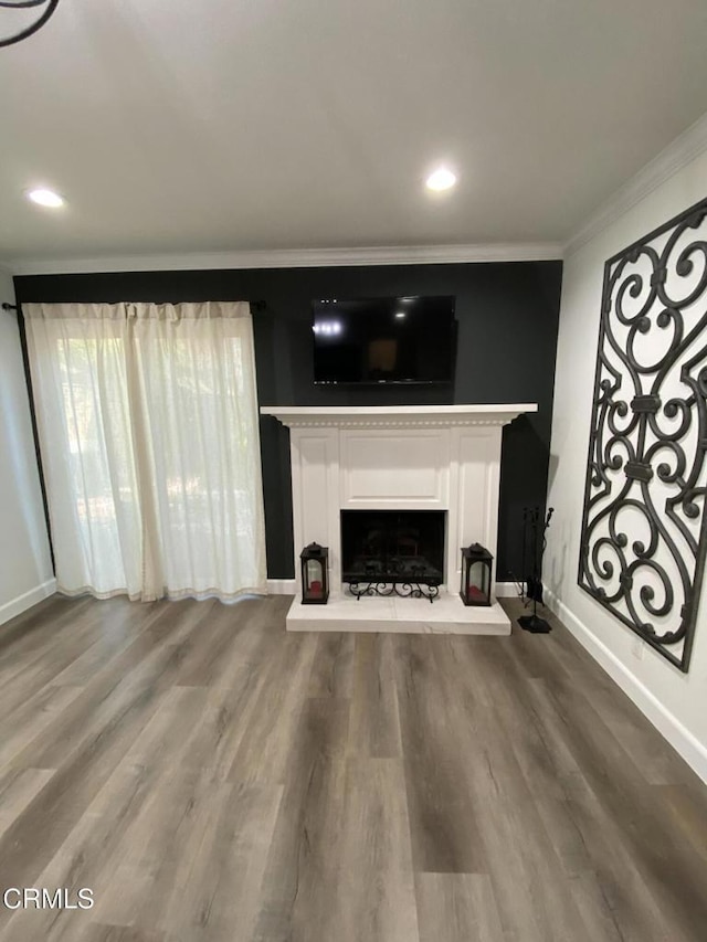 unfurnished living room featuring crown molding and hardwood / wood-style flooring