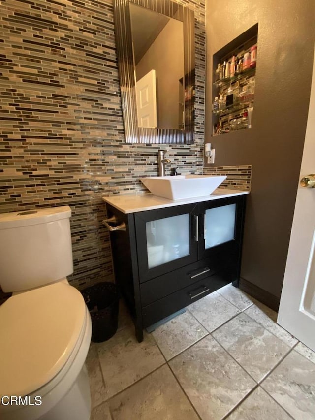 bathroom with backsplash, toilet, and vanity