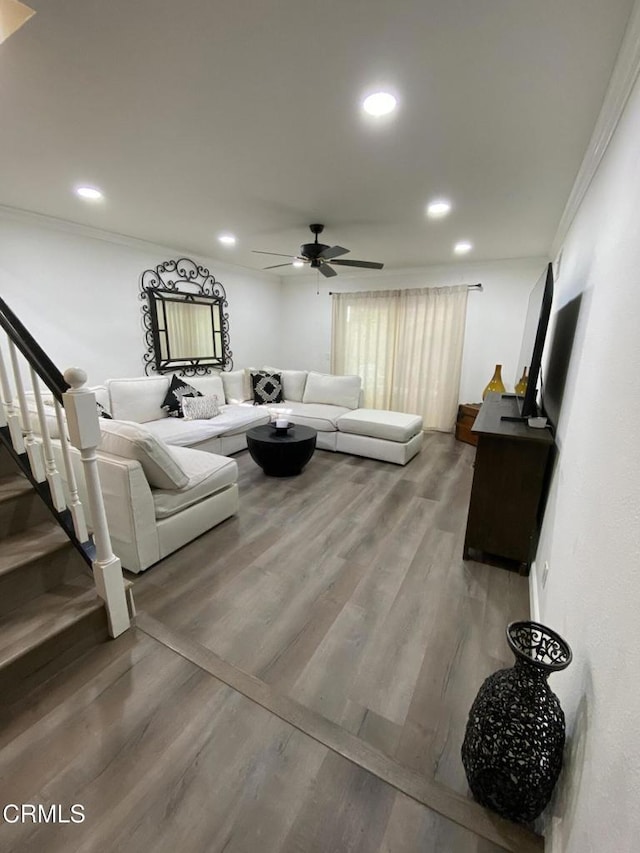 living room featuring hardwood / wood-style flooring, ornamental molding, and ceiling fan