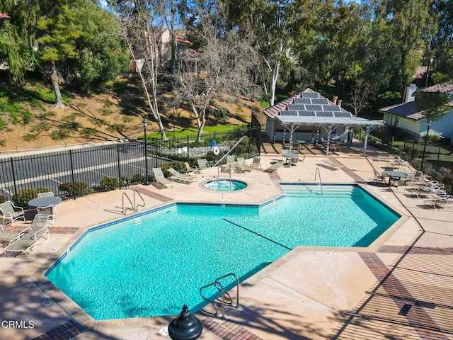 community pool featuring a patio, a community hot tub, and fence