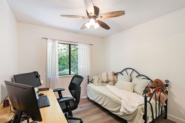 bedroom with ceiling fan, baseboards, and wood finished floors