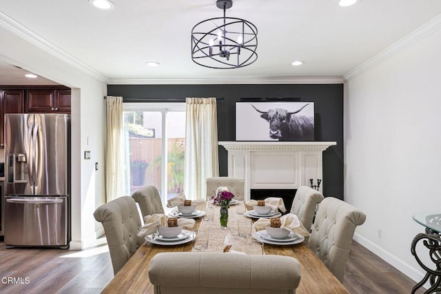 dining space featuring baseboards, wood finished floors, an inviting chandelier, and ornamental molding