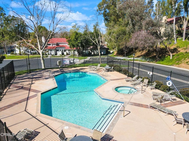 pool with a community hot tub, a patio area, and fence