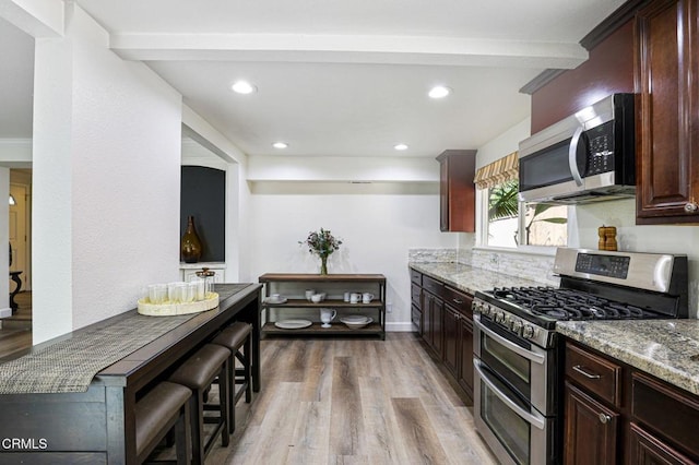 kitchen with light stone counters, stainless steel appliances, recessed lighting, and light wood finished floors