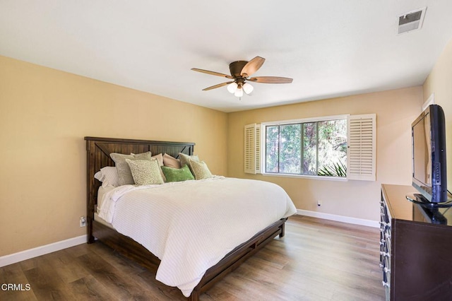 bedroom featuring visible vents, ceiling fan, baseboards, and wood finished floors