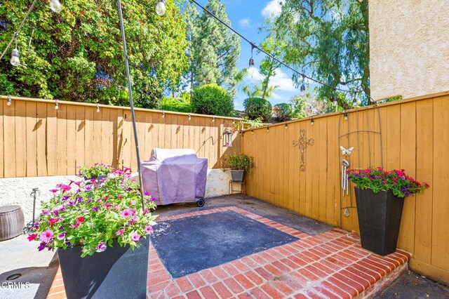 view of patio with grilling area and a fenced backyard