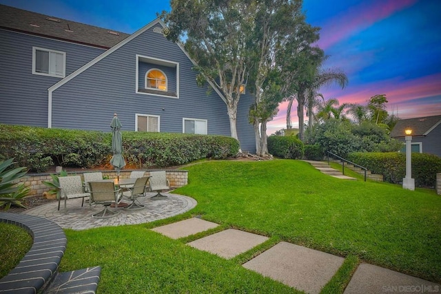 yard at dusk featuring a patio