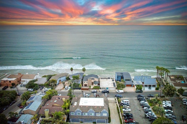 aerial view at dusk featuring a water view