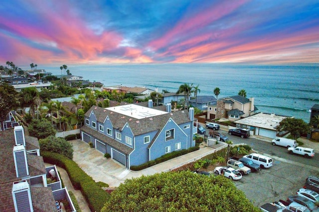 aerial view at dusk featuring a water view