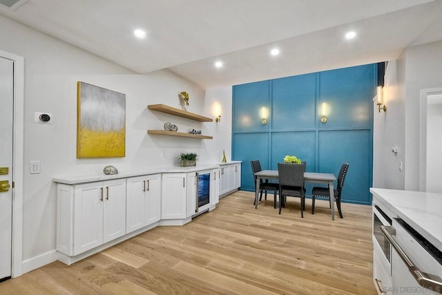 kitchen with white cabinetry, beverage cooler, dishwashing machine, and light wood-type flooring