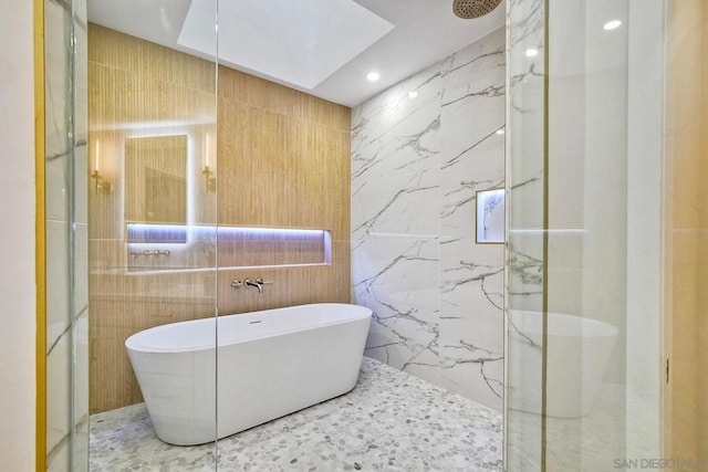 bathroom featuring tile walls, a skylight, and independent shower and bath