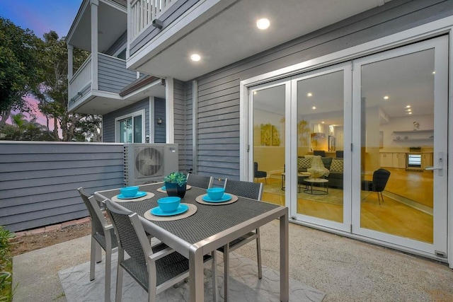 patio terrace at dusk featuring ac unit