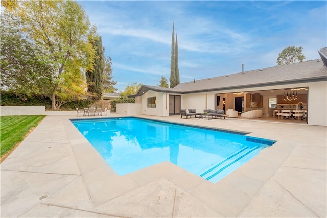 view of pool featuring ceiling fan, an outdoor living space, and a patio