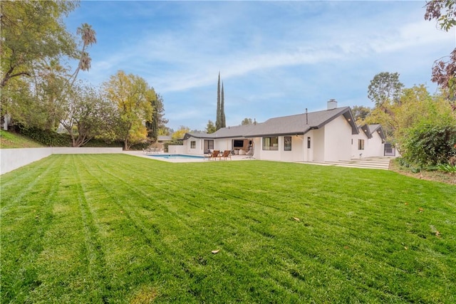 rear view of property with a lawn and a patio