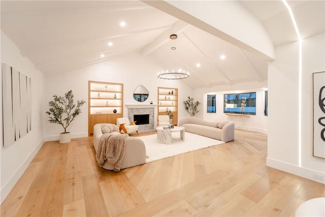 living room with vaulted ceiling with beams, built in features, an inviting chandelier, and light hardwood / wood-style flooring