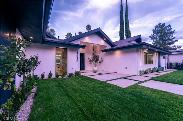 view of front of house with a patio area and a lawn