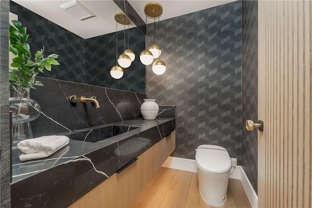 bathroom featuring sink, hardwood / wood-style floors, and toilet