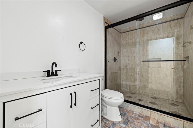 bathroom with walk in shower, vanity, and toilet