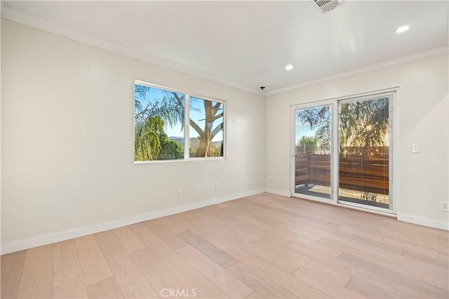 empty room featuring light wood-type flooring and ornamental molding