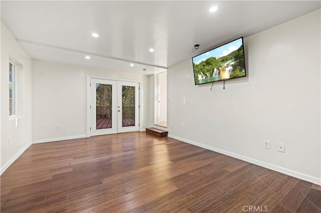 empty room with dark hardwood / wood-style floors and french doors