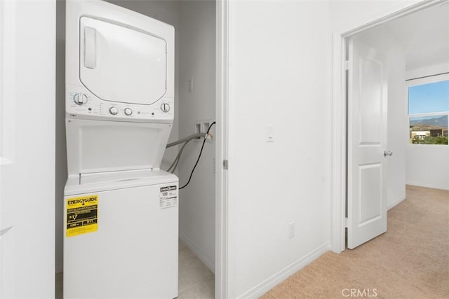 washroom with light carpet and stacked washing maching and dryer