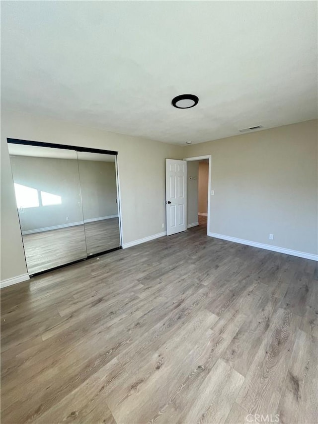 unfurnished bedroom with a closet and light hardwood / wood-style flooring