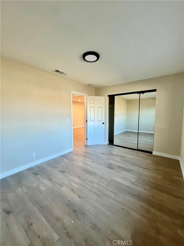 unfurnished bedroom featuring a closet and wood-type flooring