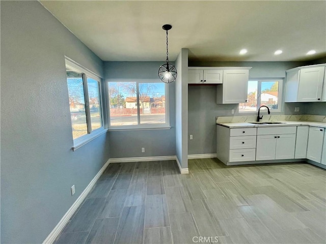 kitchen with white cabinets, pendant lighting, plenty of natural light, and sink