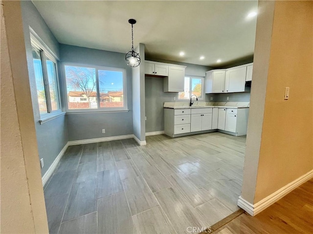 kitchen with sink, white cabinets, and pendant lighting