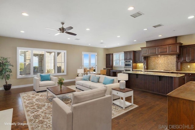 living room featuring ceiling fan, dark wood-type flooring, and sink