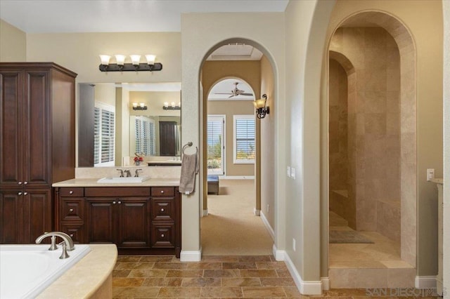 bathroom with ceiling fan, vanity, and shower with separate bathtub