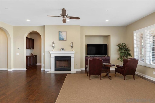 living room with ceiling fan and dark hardwood / wood-style floors