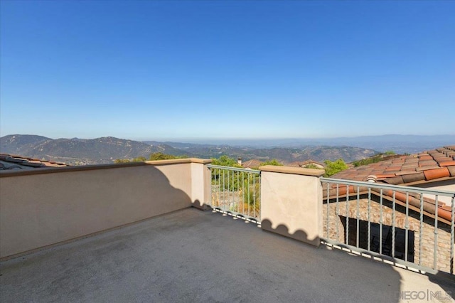 view of patio featuring a balcony and a mountain view