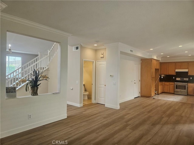 unfurnished living room featuring crown molding and hardwood / wood-style flooring