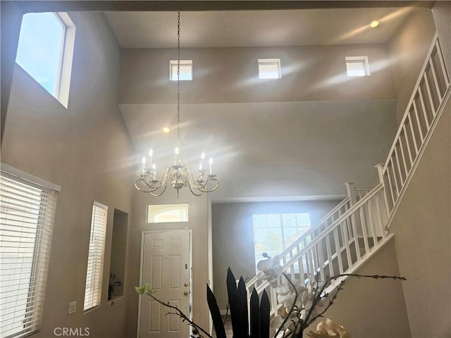 foyer with a high ceiling and an inviting chandelier