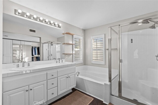 bathroom with vanity, independent shower and bath, and hardwood / wood-style flooring