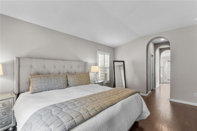 bedroom with lofted ceiling and dark hardwood / wood-style floors