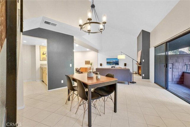 tiled dining space featuring an inviting chandelier and lofted ceiling