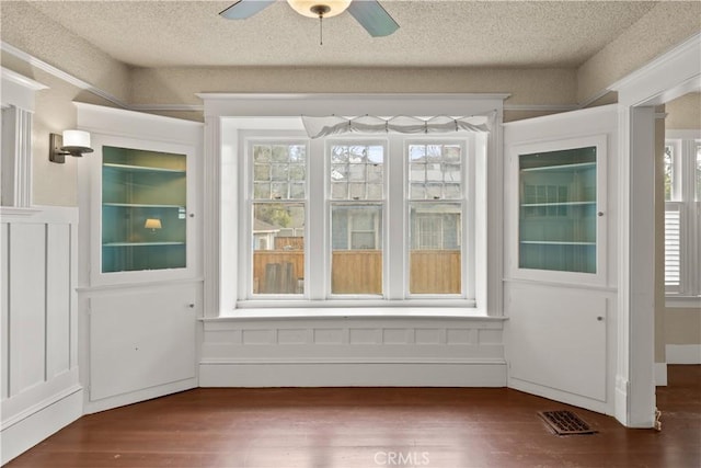 interior space featuring visible vents, a textured ceiling, ceiling fan, and wood finished floors