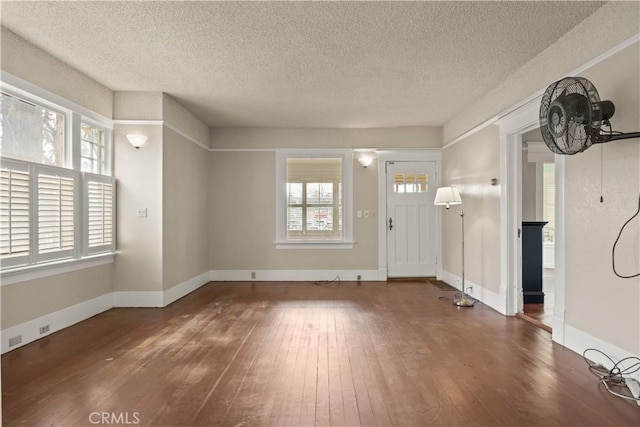 entryway with baseboards, plenty of natural light, a textured ceiling, and hardwood / wood-style flooring