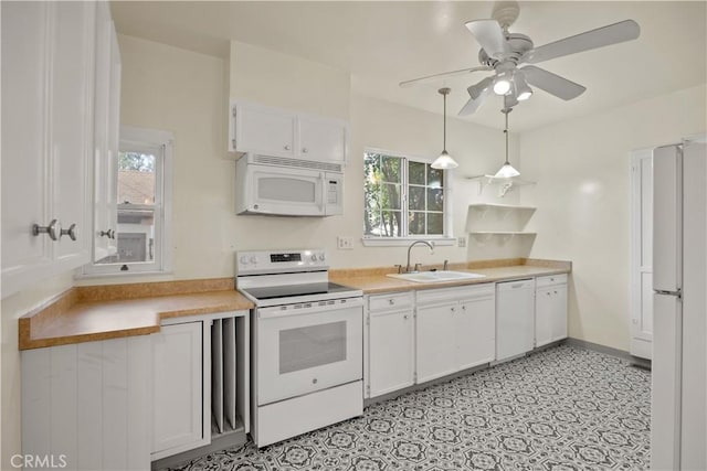 kitchen with white appliances, a ceiling fan, a sink, light countertops, and white cabinets