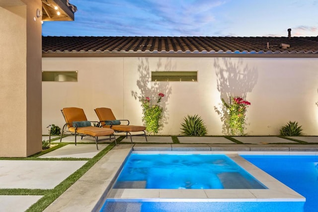 back house at dusk with a patio