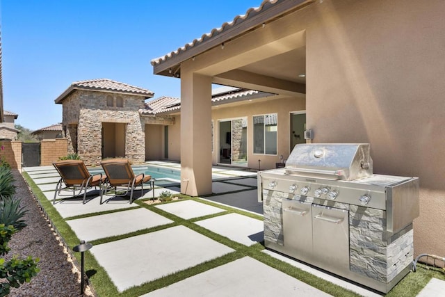 view of patio with exterior kitchen, a grill, and a fenced in pool